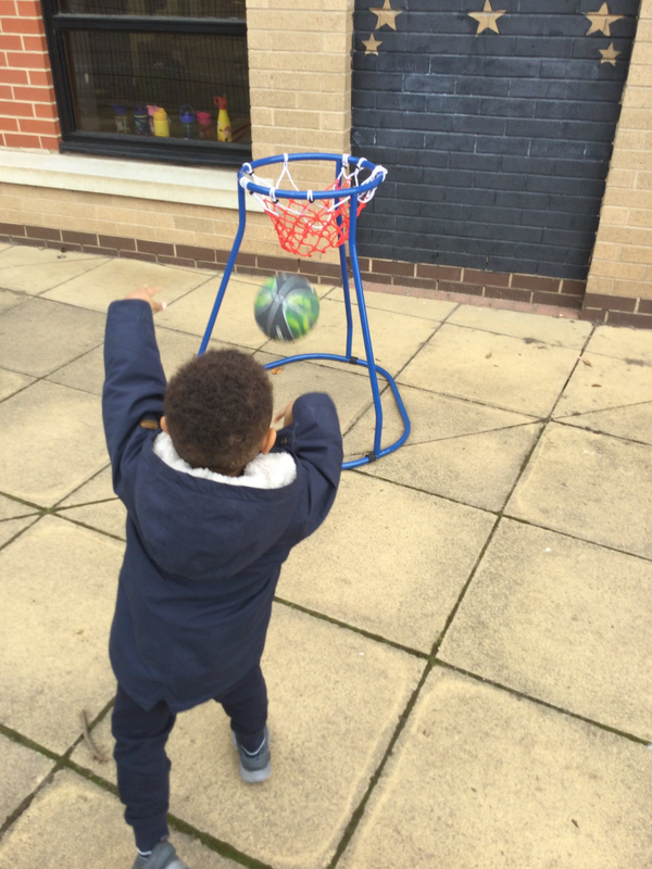 Child throwing basketball into hoop