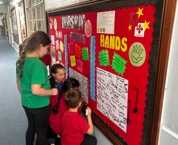 Children using our head, heart, hands worship board