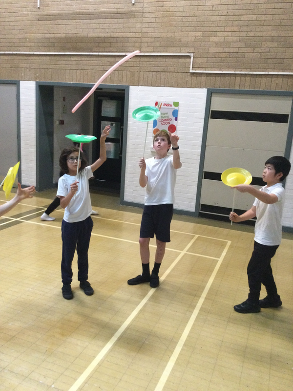 Children spinning plates in a circus workshop