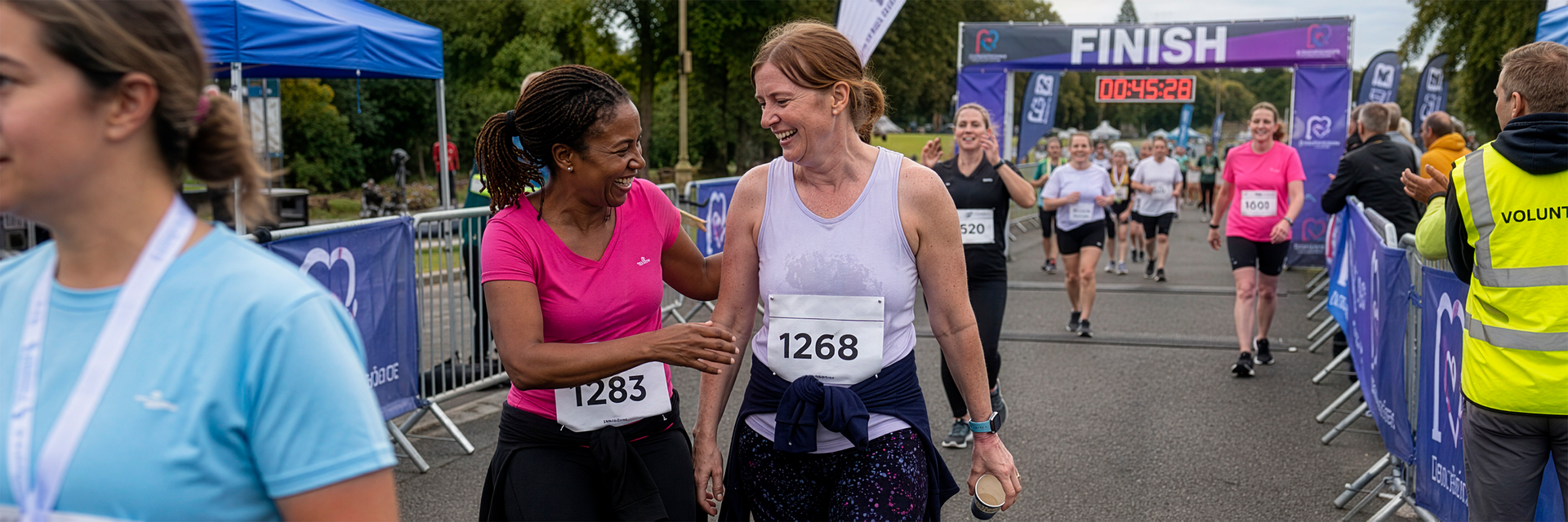 Two runners celebrating together after crossing the finish line at a fundraising event.